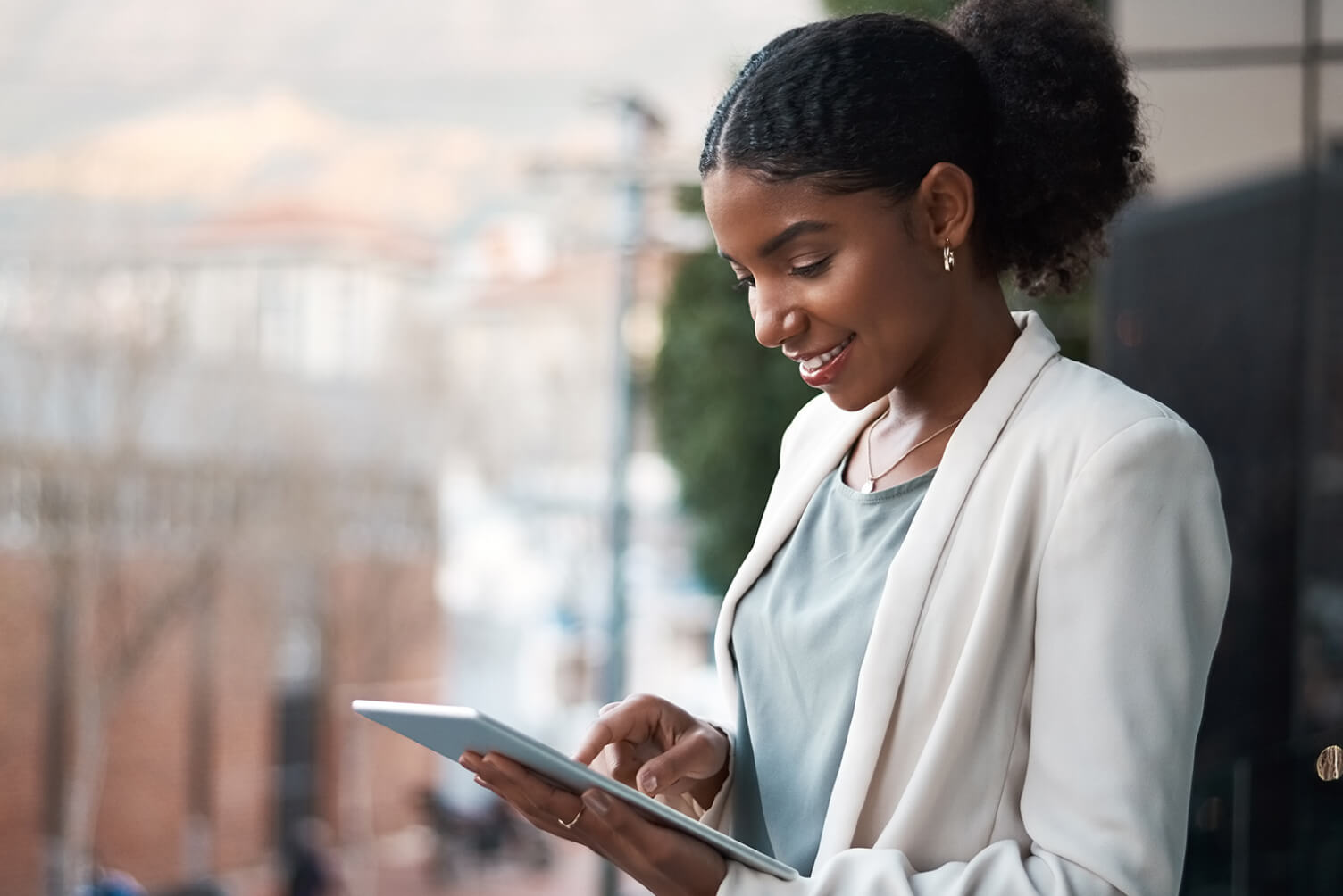 mujer sonriendo mirando una tablet